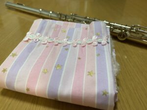 フルートマットを畳んだ状態をアップにした画像なので、飾りとピンクの袋状の生地の柄がよく分かります。