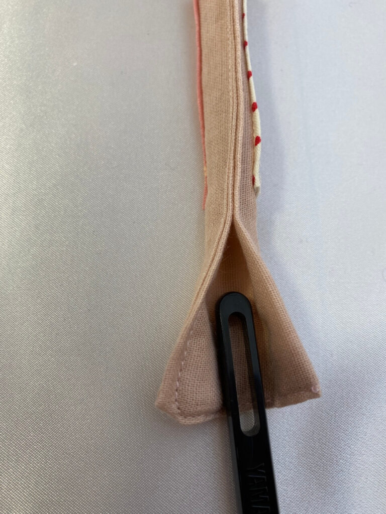 作り方⑤の状態になったものをさらに袋状になるように半分に折り、端を縫い合わせます。