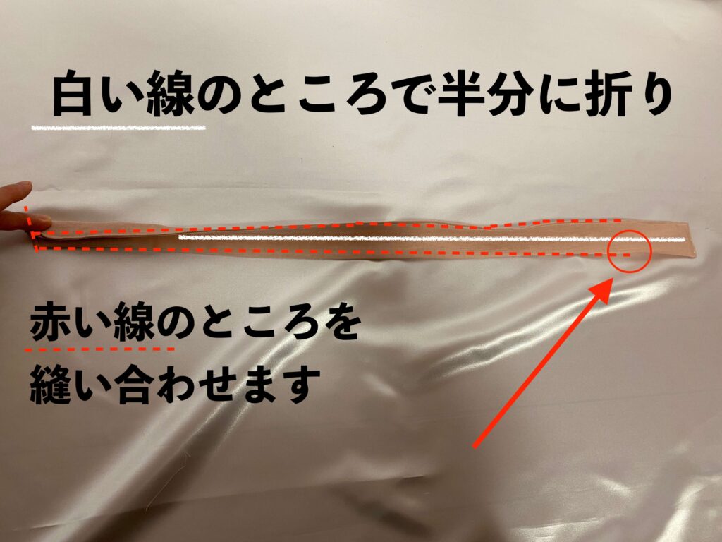 作り方④白い線のところで半分に折り、赤い線のところをミシンで縫い合わせます。